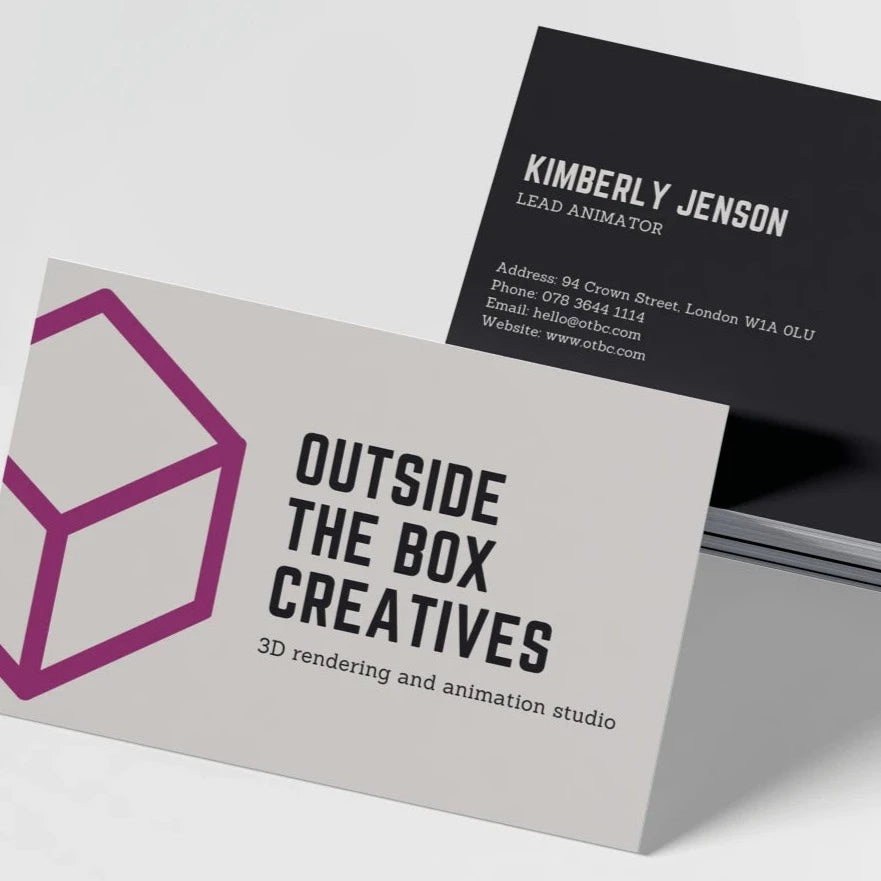 Two business cards with a matte finish. The card in the foreground has 'OUTSIDE THE BOX CREATIVES' printed on it with a stylized cube graphic.