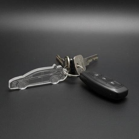 Car keys with a clear plastic keychain on a dark surface