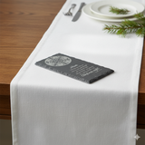 Slate coasters with engraved text on a white tablecloth