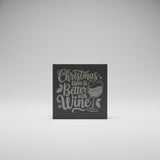 Decorative sign with 'Christmas time is better with wine' text on a dark background