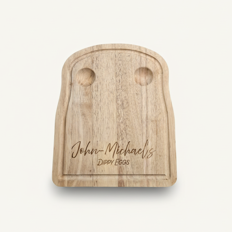Wooden toast-shaped cutting board with engraved text on a white background