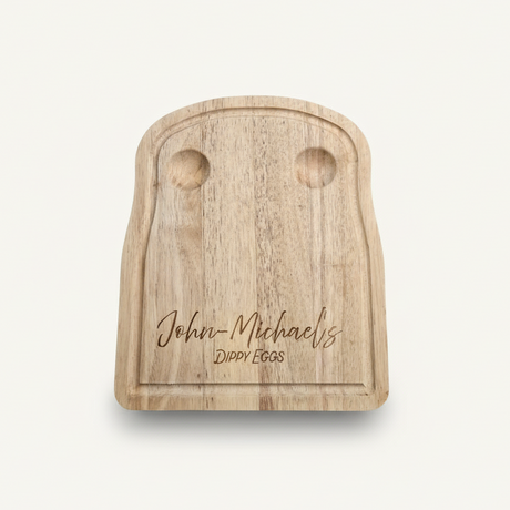 Wooden toast-shaped cutting board with engraved text on a white background