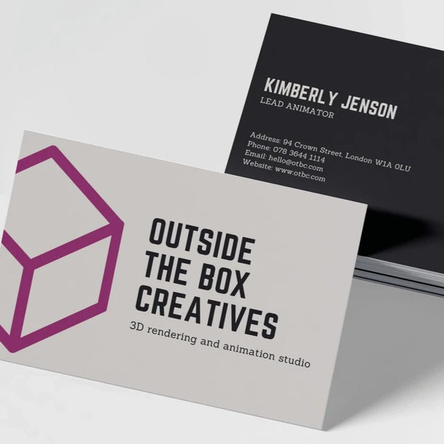 Two business cards with a matte finish. The card in the foreground has 'OUTSIDE THE BOX CREATIVES' printed on it with a stylized cube graphic.