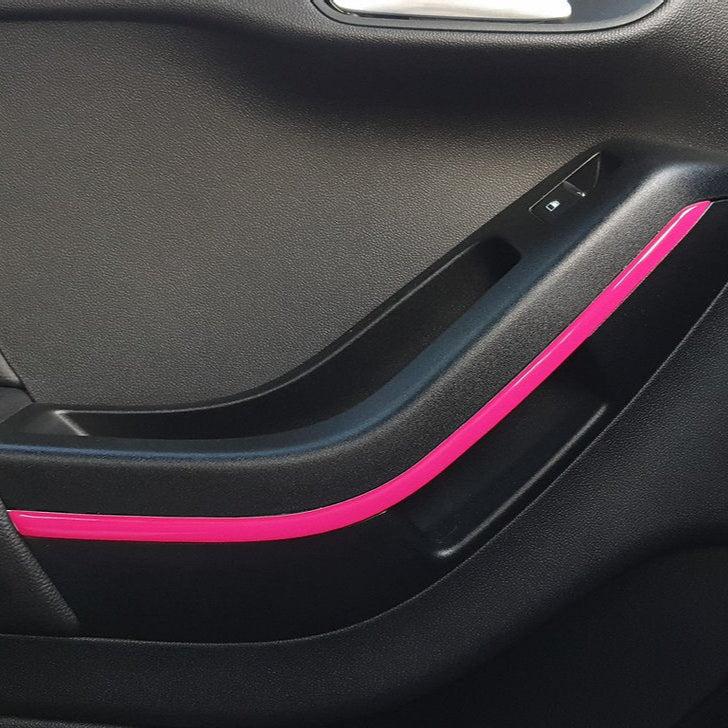 A pink gel strip applied to the interior door handle of a vehicle, replacing the chrome strip.